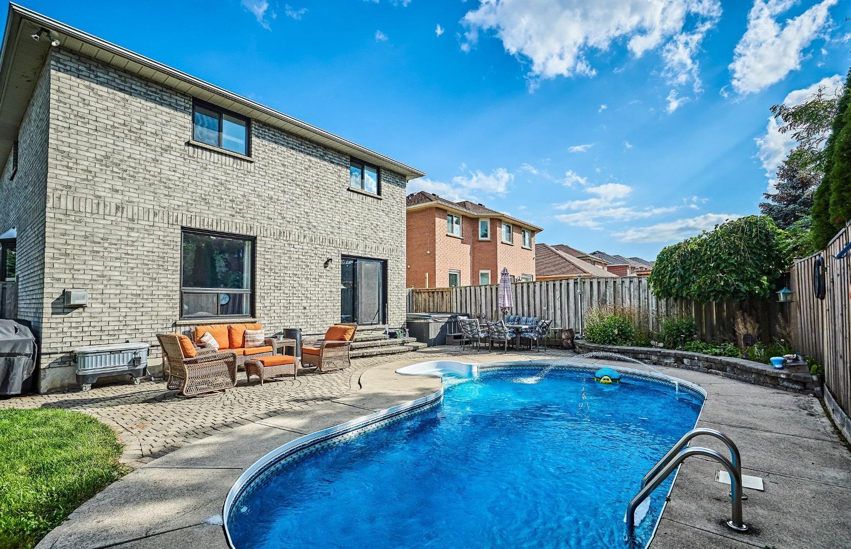 Backyard pool on a sunny day at a home for sale in Courtice, Ontario